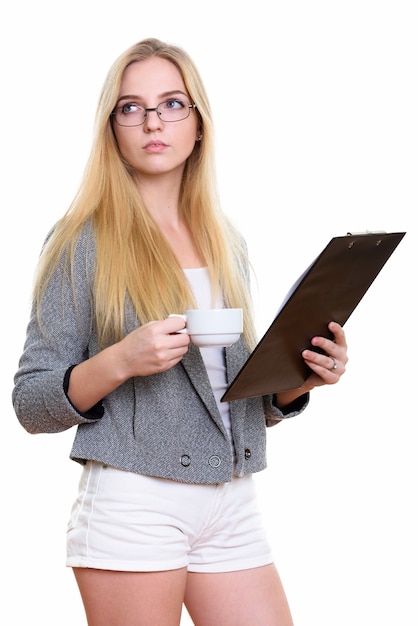 Giovane bella donna di affari che tiene appunti e tazza di caffè