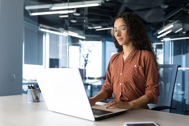 Young beautiful businesswoman working inside modern office building arab woman with curly hair and