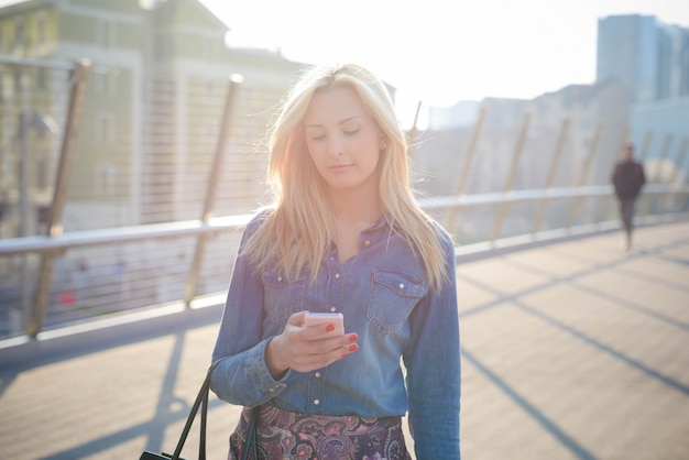 Young beautiful caucasian blonde girl in the city