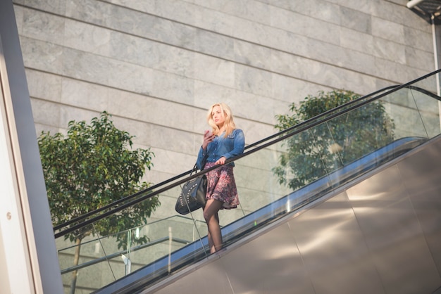 Young beautiful caucasian blonde girl in the city