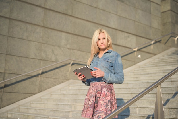 Young beautiful caucasian blonde girl in the city