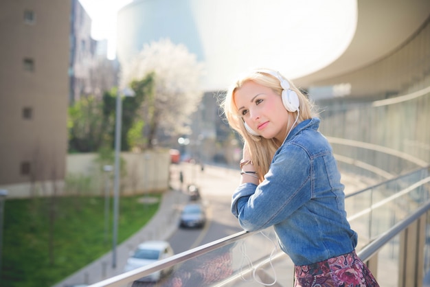 都市の若い美しい白人のブロンドの女の子