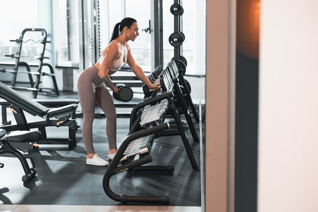 Young beautiful caucasian fit strong woman is doing exercises in gym