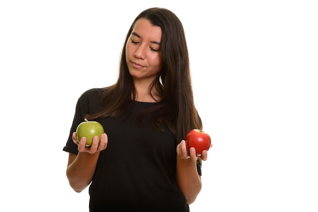 Young beautiful Caucasian woman choosing between red and green apple