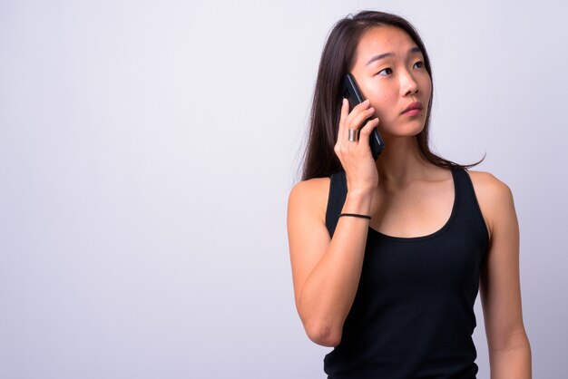  young beautiful Chinese woman against white wall