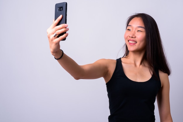  young beautiful Chinese woman against white wall