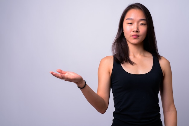 Photo young beautiful chinese woman against white wall