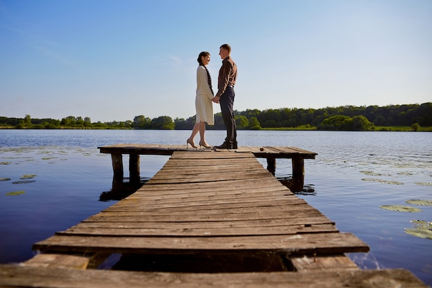 Photo young beautiful couple on a bridge