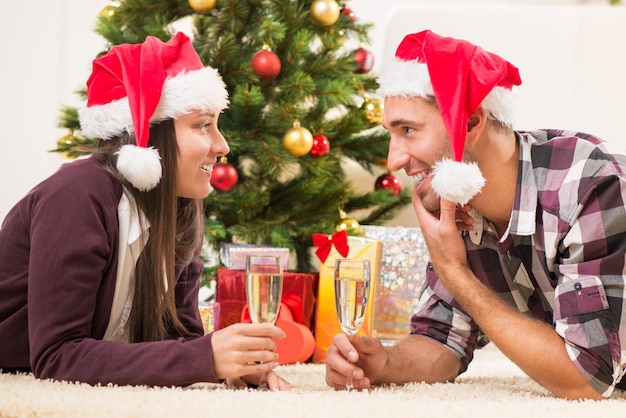 シャンパングラスでクリスマスや新年を祝う若い美しいカップル。
