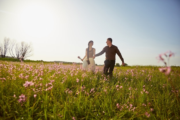 Young beautiful couple in a field with flowers