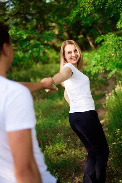 Young beautiful couple hand by hand on natural background.