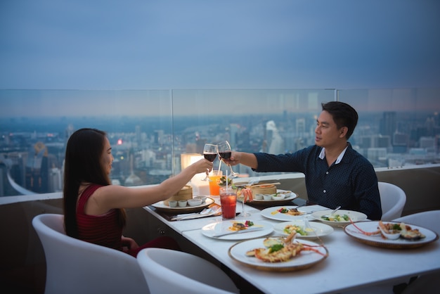 Young beautiful couple having romantic dinner on rooftop at night.