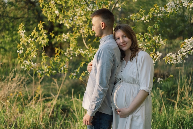 Young beautiful couple hugging in the spring garden