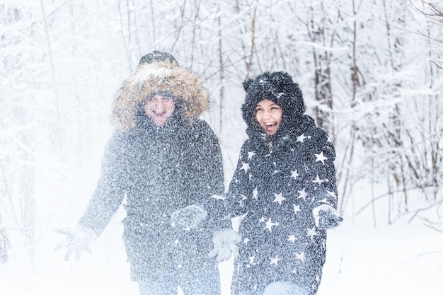 A young and beautiful couple is having fun in the park during winter