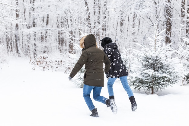 A young and beautiful couple is having fun in the park during winter