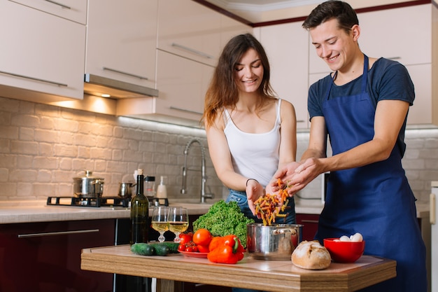 Young beautiful couple in kitchen. family of two preparing food. making delicious pasta