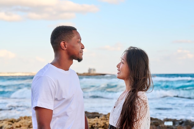 Young beautiful couple looking in the eyes in profile on the seascape