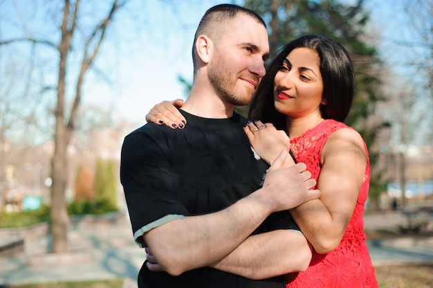 Young beautiful couple in love posing outdoor in city. Young woman smiling with her handsome man.