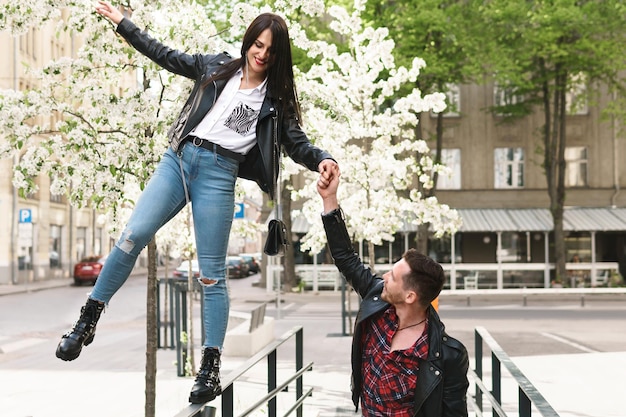 Young and beautiful couple in love wearing leather jackets during a date on a city street