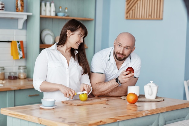 A young beautiful couple prepares Breakfast together in the kitchen on a weekend morning