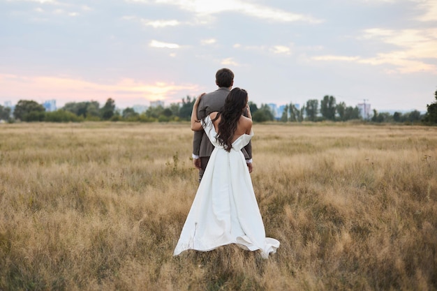 Young beautiful couple at sunset in the field