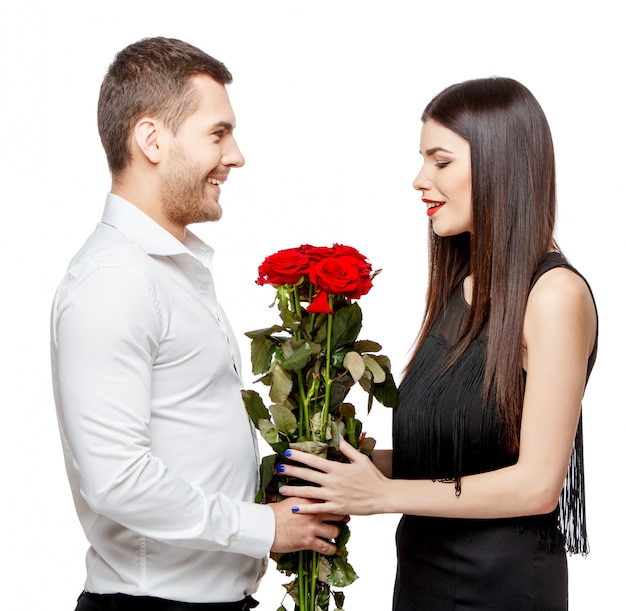 Young beautiful couple with flowers on white