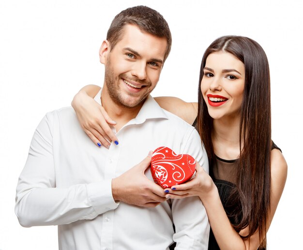 Young beautiful couple with present on white