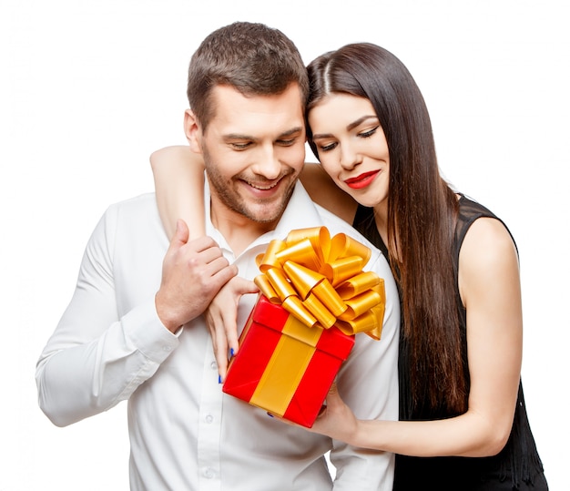 Young beautiful couple with present on white