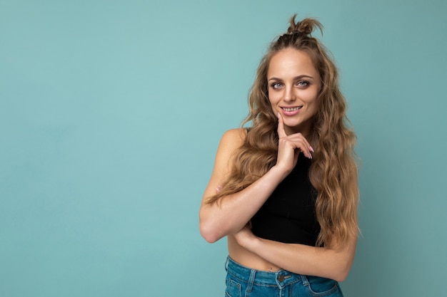 Young beautiful curly blonde woman with sexy expression cheerful and happy face wearing trendy black