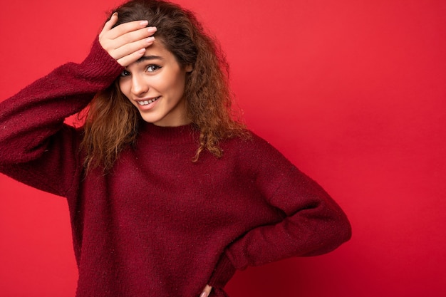 Foto giovane bella donna castana riccia con emozioni sincere in bilico isolata sulla parete di fondo con