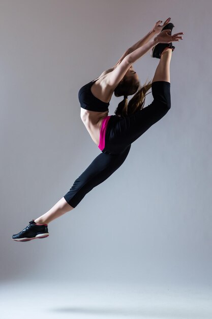 young beautiful dancer posing on a studio background