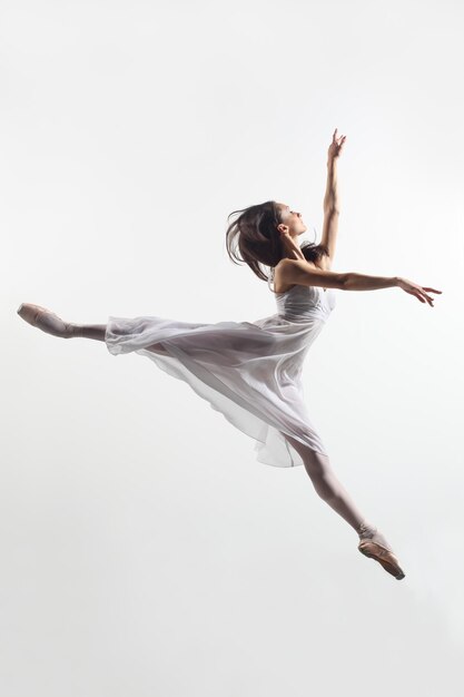 young beautiful dancer posing on a studio background