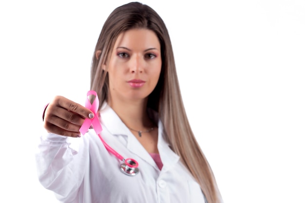Молодая красивая женщина-врач с розовым стетоскопом и розовой лентой осведомленности для рака груди.
