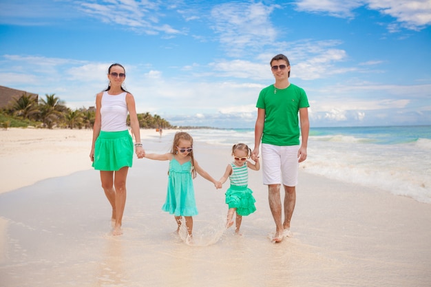 Young beautiful family of four enjoyed relaxing on the beach