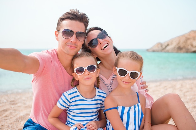 Young beautiful family taking selfie on the beach