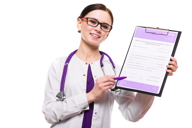 Young beautiful female doctor showing on clipboard with pen on white 