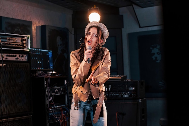 Young beautiful female performer rehearsing in a recording studio