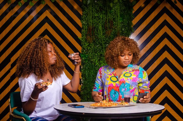 Young beautiful females hanging eating pizza