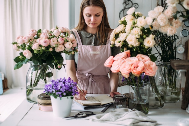 Young beautiful florist in a flower shop