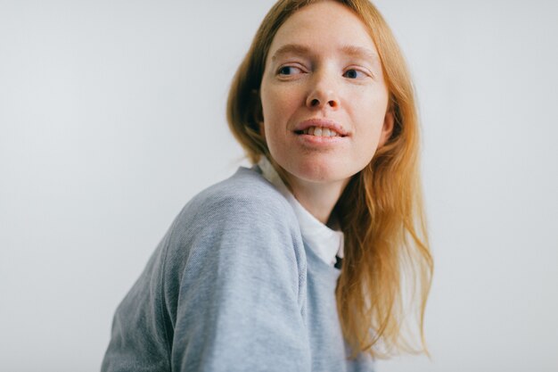 Young beautiful freckles girl with long red hair studio portrait