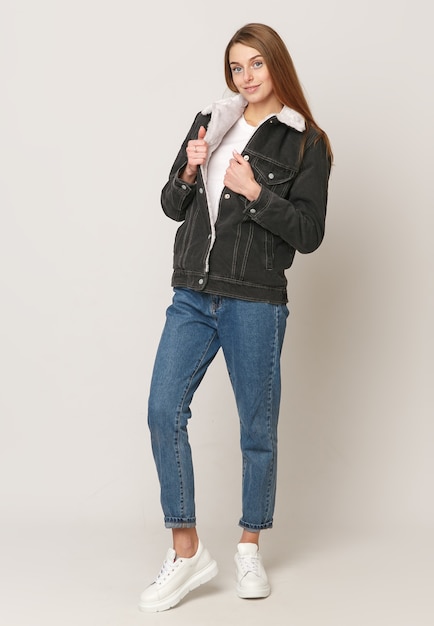 Young beautiful girl in a denim gray sweater on a white background .. Concept of beauty and fashion, Concept of jeans.