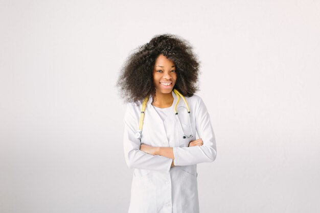 Молодая красивая девушка доктор в белом халате с помощью стетоскопа. на белом фоне
