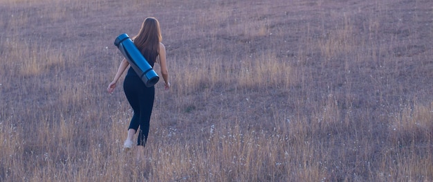 Giovane bella ragazza che fa yoga in natura