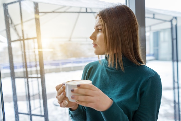 Young beautiful girl drinking coffee