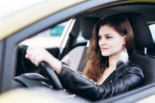 Foto giovane bella ragazza che guida un'auto