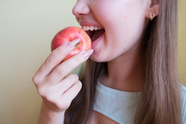 Young beautiful girl eating an apple closeup