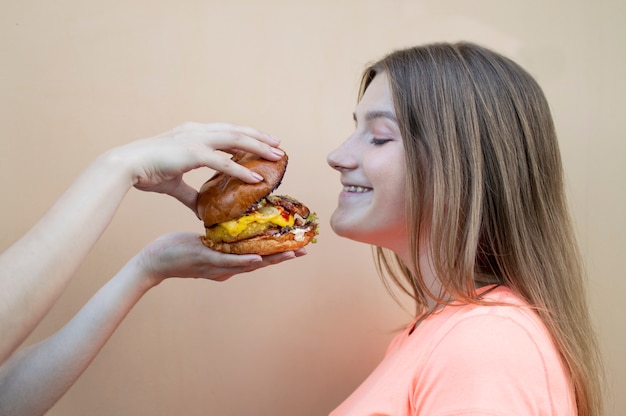 Young beautiful girl eating a hamburger