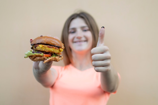 Young beautiful girl eating a hamburger