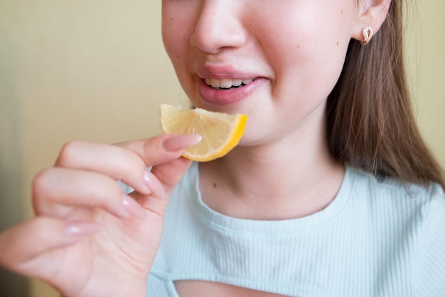 写真 レモンを食べている美しい若い女の子のクローズアップ写真レモンのスライスを食べている口