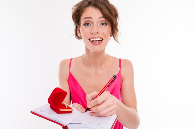 Young beautiful girl holds a box for a engagement ring and planning wedding isolated on white 